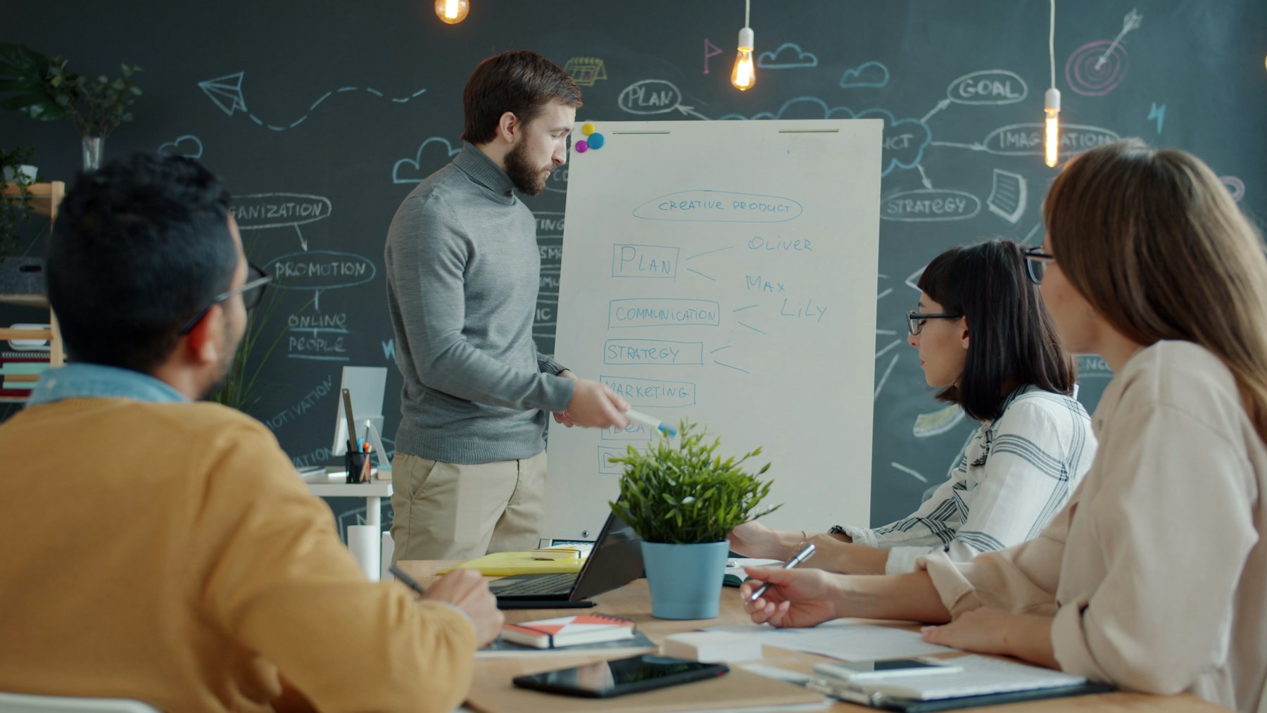 Engineers sketching a system architecture on a whiteboard